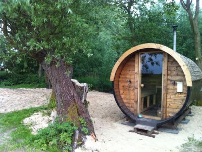 Die urige Fass-Sauna mit Blick auf den Teich